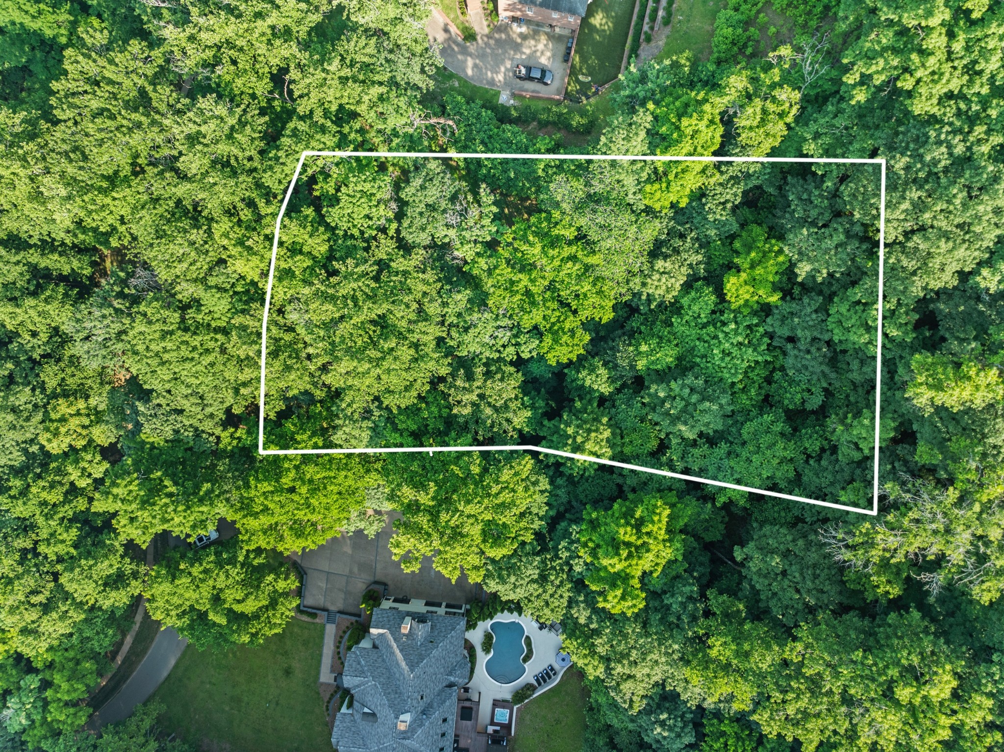 Top-down drone view of the 2.01-acre parcel outlined in white