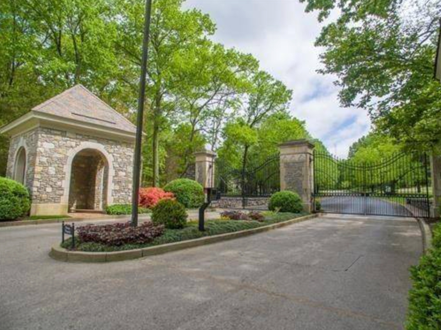 The front gate at the entrance to Otter Wood, with stone columns and ornamental wrought iron