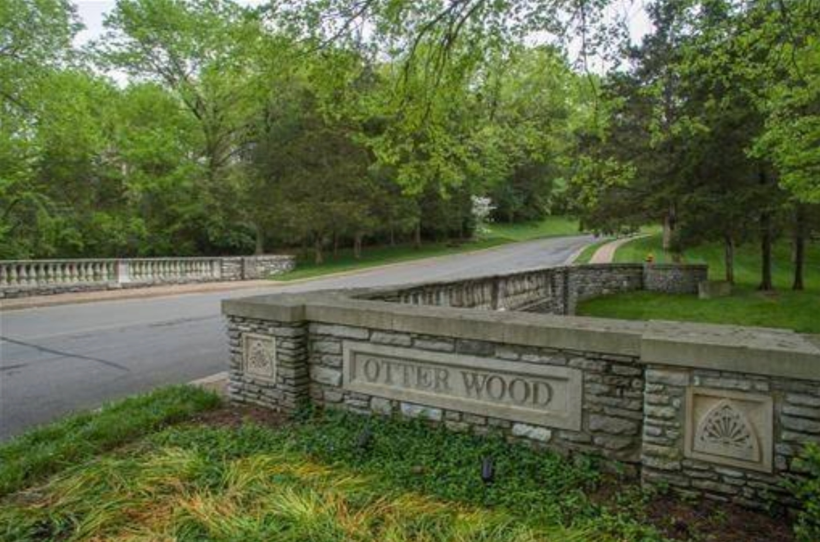 The carved Otter Wood entrance sign set into landscaped stone