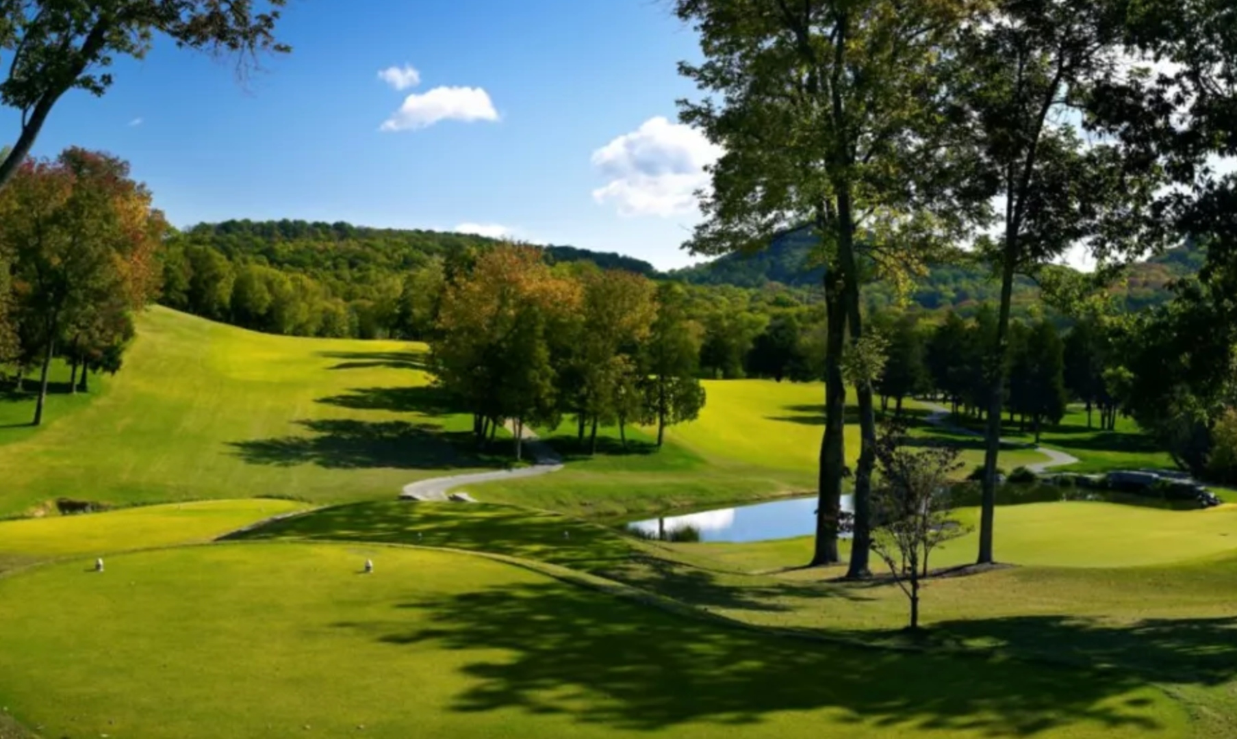 Manicured fairway at Richland Country Club with a pond and the rolling Tennessee hills beyond